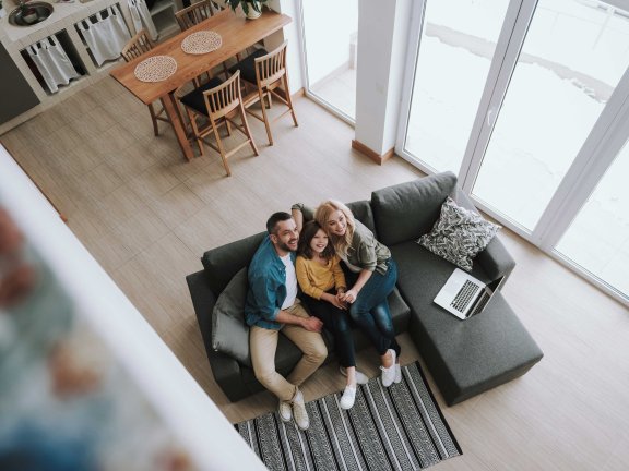 Eine Familie sitzt zusammen auf dem Sofa.