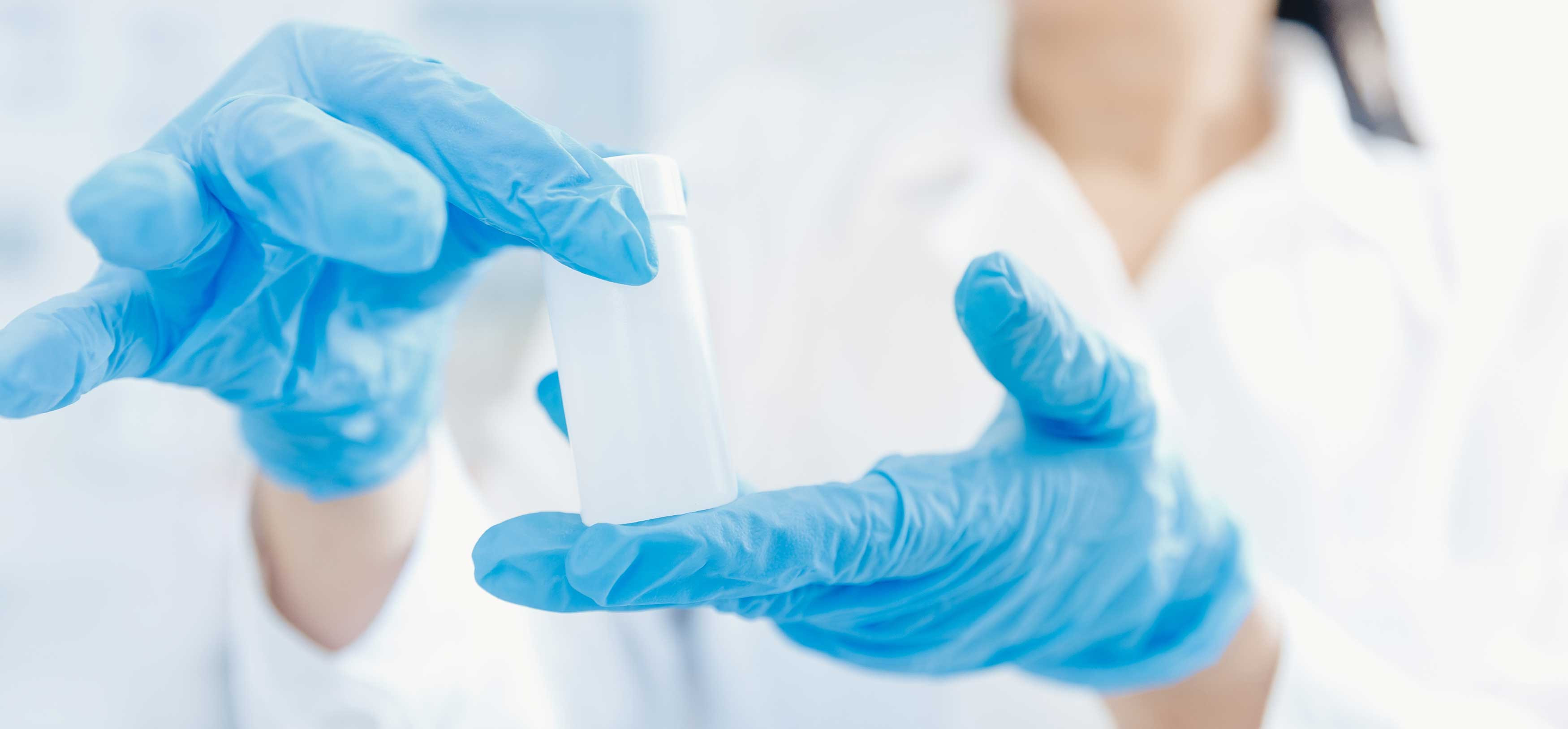 Chemiker mit blauen Gummihandschuhen hält Wasserproben zur Untersuchung